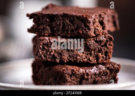 Brownie di cioccolato fondente. Tre deliziosi pezzi quadrati di caramelle di cioccolato fondente su un piatto, vista closeup Foto Stock