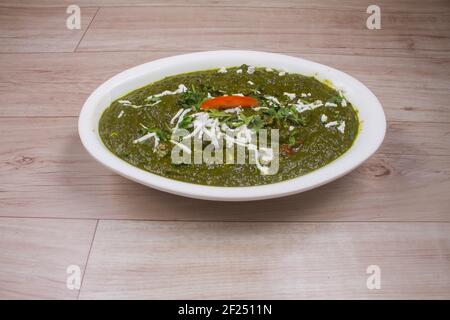 Palakpaneer o Spinach e Cottage formaggio di curry, mortaio con spezie su sfondo scuro. Piatto tradizionale indiano. Vista dall'alto, spazio di copia Foto Stock