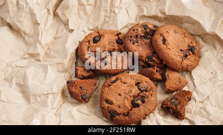 Vista su alcuni biscotti fatti a mano al cioccolato con scaglie di cioccolato sulla cottura carta Foto Stock