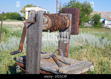 Moderno rustico legno estrazione acqua bene Rusty catena Foto Stock