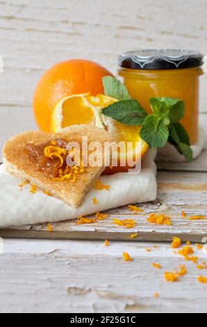 Toast a forma di cuore con marmellata d'arancia su un tovagliolo bianco Foto Stock