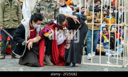 Migliaia di tibetani e sostenitori protestano per le strade di piazza Trocadero vicino alla famosa Torre Eiffel di Parigi per commemorare il 62° anniversario della Giornata Nazionale d'rivolta tibetana. Un gioco di strada è stato organizzato sulla recente morte di Tenzin Nyima, un monaco tibetano di 19 anni a causa della tortura nella prigione cinese. Foto Stock