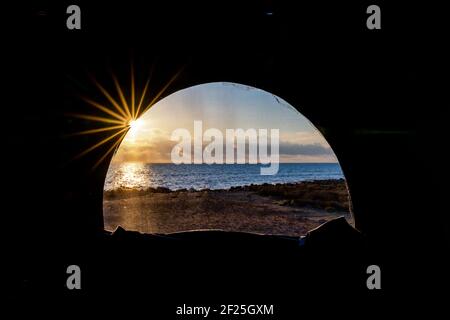 vista di una splendida alba sull'oceano attraverso finestra di un tetto a scomparsa in un camper con una stella solare Foto Stock