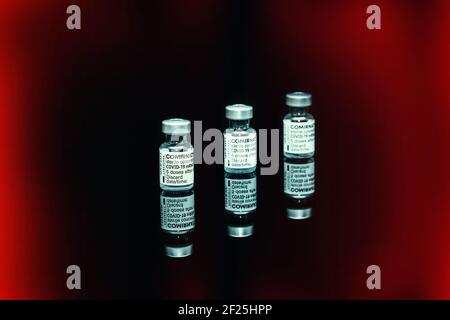 PRAGA, CZE - 10 marzo 2021. COVID-19 fiale vaccinate con virus SARS. Vaccino mRNA COMIRNATY su retro nero. Siringa con vaccino COMIRNATY contro S Foto Stock