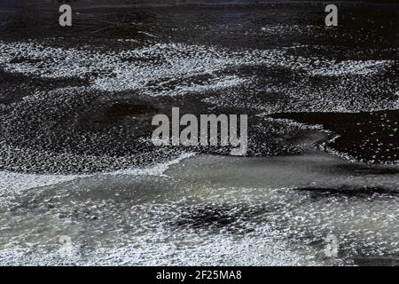 Modelli di neve sulla superficie congelata del fiume Morto nel mese di febbraio nella contea di Marquette, Michigan, Stati Uniti Foto Stock