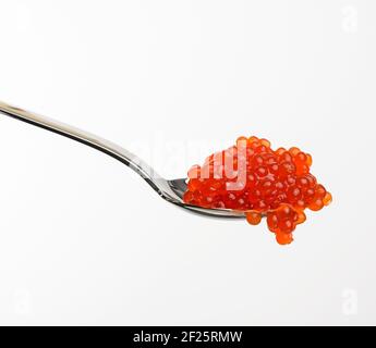 Caviale fresco di salmone al chum rosso granato in cucchiaio metallico, fondo bianco Foto Stock