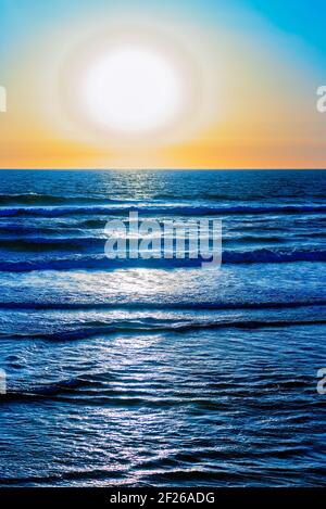 Il cielo e l'oceano si incontrano sotto cieli luminosi e soleggiati. Foto Stock