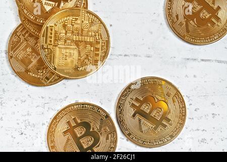 Vista dall'alto, BTC commemorativa d'oro - criptovaluta bitcoin - monete sparse su tavola di pietra bianca, dettaglio closeup Foto Stock