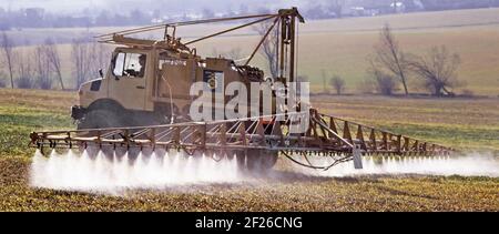 Storico 1988 primavera campagna archivio immagine di camion Mercedes dotato di attrezzature di irrorazione del raccolto per agricoltura anni '80, il conducente dell'agricoltore è in funzione Su un terreno agricolo in pendenza nel paesaggio rurale archivistico Essex Come eravamo negli anni '80 Mountnessing Brentwood Inghilterra REGNO UNITO Foto Stock