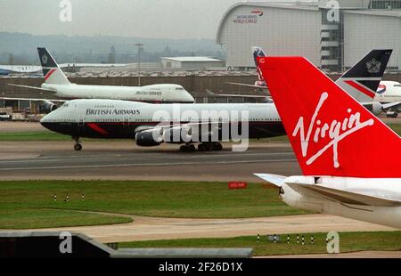 Aeroporto di Heathrow Giugno 2001 UN jumbo British Airways Boeing 747 Il 1999 novembre atterra a Heathrow e i taxi passano la coda Di una Virgin Atlantic Airways 747 Foto Stock