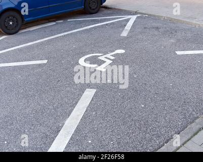Parcheggio con cartello dipinto di bianco per disabili Foto Stock