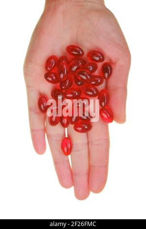 Capsule di olio di krill. Capsule di gelatina rossa con olio di krill isolato a mano su sfondo bianco. Acidi grassi omega. Vista ravvicinata degli integratori di olio di krill Foto Stock