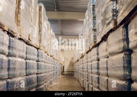 Le bottiglie di plastica sui pallet sono immagazzinati nel magazzino e. Stoccaggio in plastica in fabbrica su pavimento e scaffalatura Foto Stock