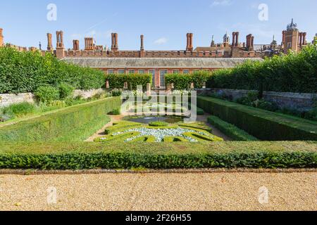 Tudor facciata di Hampton Court Palace con la mostra in primo piano i colorati giardini sommersi Foto Stock