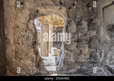 Antiche grotte di Uplistsikhe Georgia vicino al fiume Mtkvari utilizzati Da pagani e cristiani - porta che conduce in un'altra stanza con area di stoccaggio intagliata Foto Stock