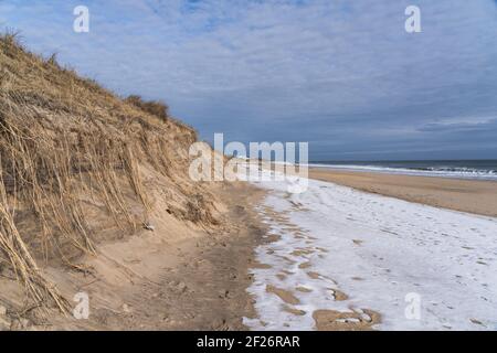 La spiaggia di Montauk durante l'inverno, con neve che copre parte della sabbia Foto Stock