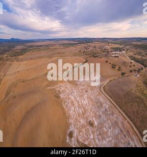 Drone panorama aereo di un deserto come paesaggio collinare con pietre di marmo polvere al tramonto a Terena, Portogallo Foto Stock