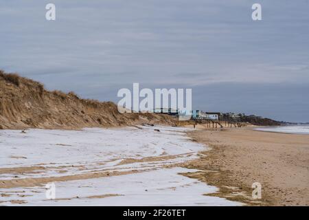 La spiaggia di Montauk durante l'inverno, con neve che copre parte della sabbia Foto Stock