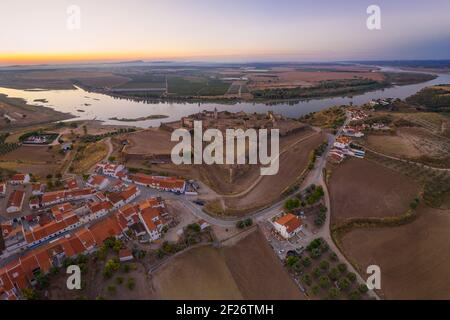 Il castello di Juromenha, il villaggio e il drone del fiume Guadiana vista aerea al tramonto ad Alentejo, Portogallo e S Foto Stock