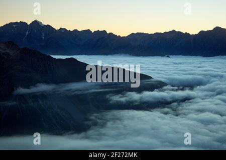 Strato di inversione di mattina presto della nuvola bassa sopra il villaggio di Mt Cook, Aoraki / il parco nazionale di Mount Cook, l'isola del sud, la Nuova Zelanda Foto Stock