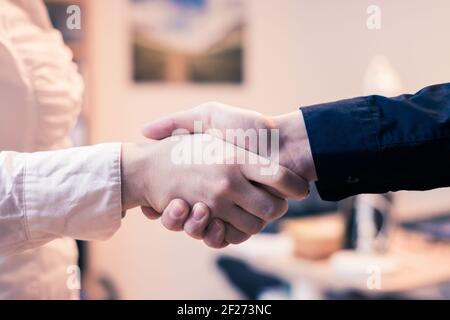 Mani agitanti, concetto per il lavoro di squadra: Primo piano di uomo e donna che scuotono le mani in ufficio Foto Stock