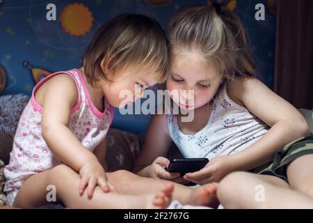 suore a letto guardando smartphone. concetto tecnologico Foto Stock