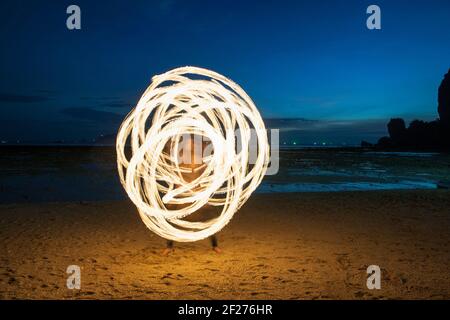 Danzatrice del fuoco che si esibisce sulla spiaggia di Railay Foto Stock