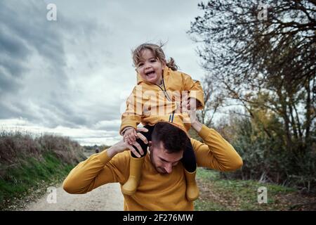 Una ragazza di due anni che si diverte con il suo papà in natura Foto Stock
