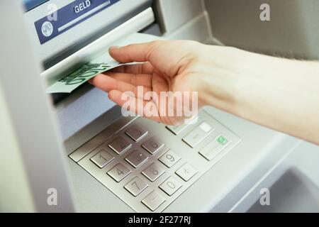 Chiudere op di giovane donna che ritira denaro da un atm Foto Stock