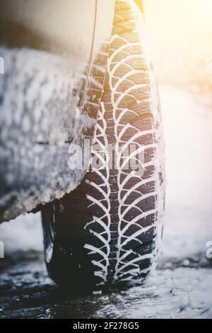 Pneumatico auto in inverno sulla strada coperta di neve, primo piano immagine Foto Stock
