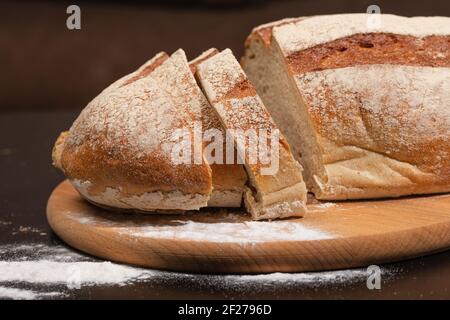 Prodotti da forno fatti in casa. Pane appena sfornato su una tavola di legno. Fette di pane. Foto Stock