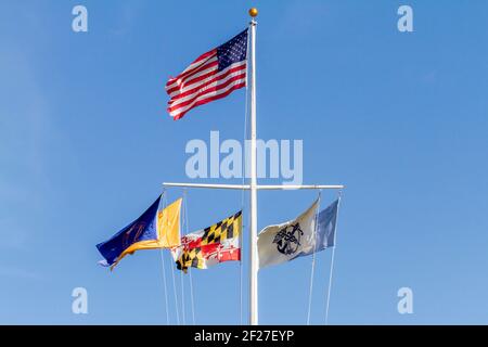 Silverspring, MD, USA 11-14-2020: Un palo Nautico a forma di T con la bandiera degli Stati Uniti in cima e bandiere degli uffici governativi allineate sotto. Bandiere che volano Foto Stock