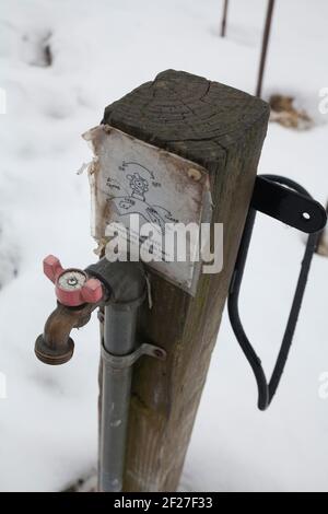 Rubinetto d'acqua comunale in un giardino della comunità del New England in inverno. Foto Stock