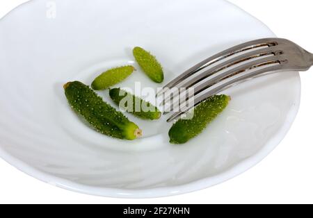 Cetrioli molto piccoli su un piatto con tappo Foto Stock