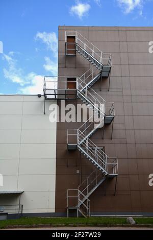 un caminetto esterno sfugge alle scale sulla moderna parete dell'edificio Foto Stock