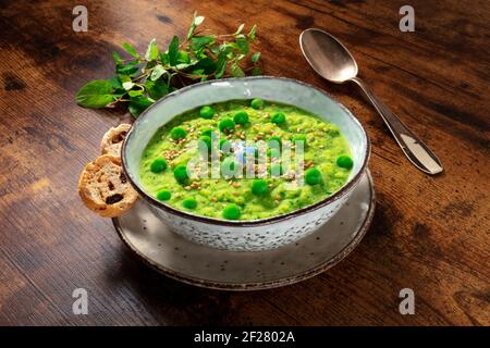 Zuppa vegana con menta e piselli verdi, con pane tostato Foto Stock