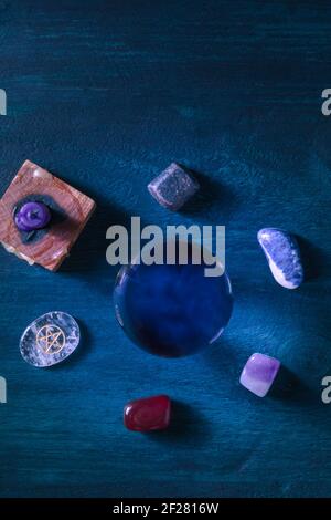 Fortune che dice. Una sfera magica, sopra tiro piatto con cristalli e una candela Foto Stock