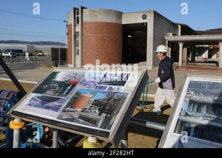 Ishinomaki, Giappone. 9 marzo 2021. Le foto della scuola prima del disastro sono esposte presso le rovine della scuola elementare Okawa a Ishinomaki, Giappone, 9 marzo 2021. Una scuola elementare pubblica nella prefettura di Miyagi ha perso più di 80 vite nello tsunami a seguito del terremoto del 2011 marzo nel Giappone nordorientale. Dieci anni dopo, le rovine dell'edificio scolastico raccontano ancora l'inimmaginabile tragedia della calamità. PER ANDARE CON 'Feature: 10 anni dopo, la scuola giapponese di tsunami-colpito ancora dice tragedia inimmaginabile' Credit: Du Xiaoyi/Xinhua/Alamy Live News Foto Stock