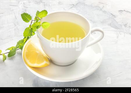 Una foto di una tazza di tè con limone e. menta Foto Stock