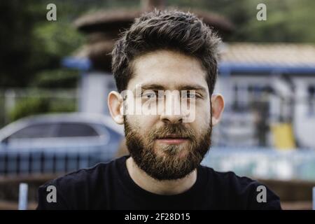 Un primo piano di un bell'uomo ispanico portava dentro il parco Foto Stock