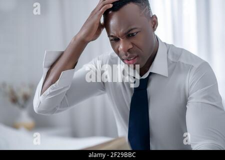 Uomo elegante che legge un giornale e guarda sconvolto Foto Stock