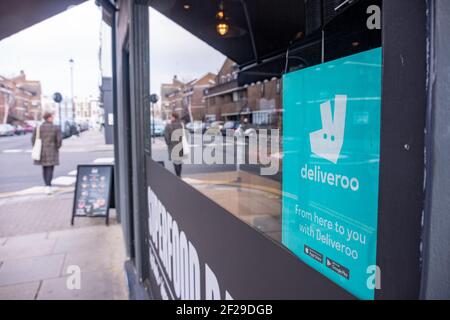 Londra - segno Deliveroo nella finestra del caffè, un servizio popolare di consegna di cibo nel Regno Unito Foto Stock