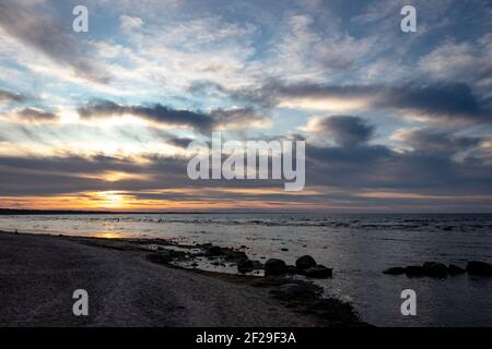 Blu sera sole sera, tramonto sul mare, costa rocciosa del mare, Mar Baltico, Golfo di riga Foto Stock