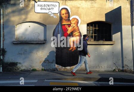 Padova, Italia. Un murale di Maria, madre di Gesù contro lo smog. La Vergine Maria tappa con le dita il naso del bambino Gesù. Foto Stock