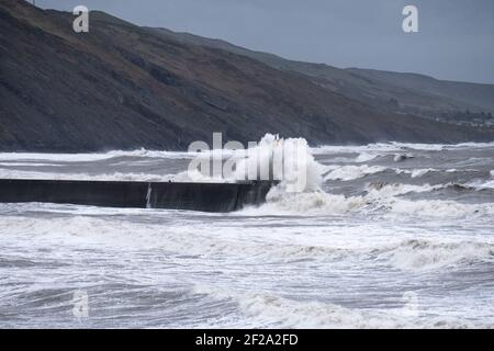 Aberystwyth, Ceredigion, Galles, Regno Unito. 11 Marzo 2021 tempo in Gran Bretagna. Un enorme rigonfio e venti potenti creano grandi onde che batte la città costiera di Aberystwyth. © Rhodri Jones/Alamy Live News Foto Stock