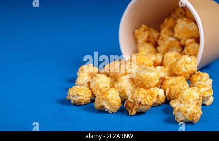 Popcorn in tazza di carta su sfondo blu Foto Stock