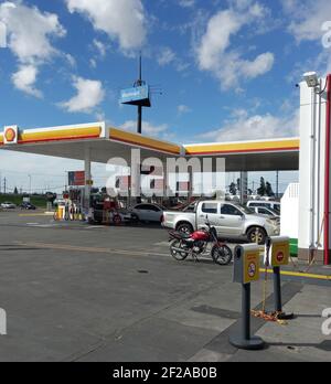 SARANDI, AVELLANEDA, BUENOS AIRES, ARGENTINA - Feb 11, 2021: Centro commerciale. Colpo di auto presso la stazione di benzina Shell accanto all'autostrada. Soleggiato d Foto Stock