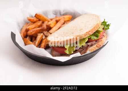 panino di manzo arrosto fatto in casa su pane di pasta frolla con croccante patatine fritte Foto Stock