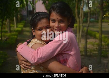 Primo piano di due belle ragazze indiane bengalesi adolescenti che si abbracciano a vicenda, focalizzazione selettiva Foto Stock