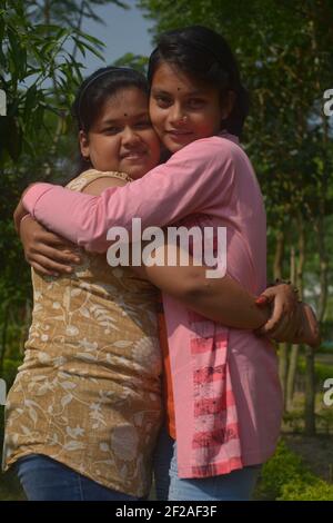 Primo piano di due belle ragazze indiane bengalesi adolescenti che si abbracciano a vicenda, focalizzazione selettiva Foto Stock